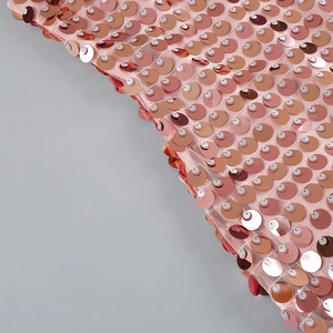 Close-up of pink sequin fabric with rose gold and champagne glitter on mesh base