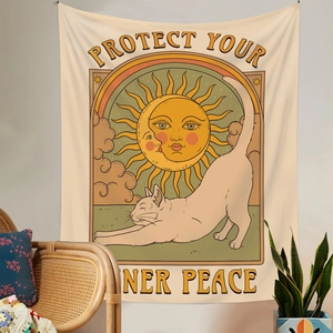 Detail of bohemian wall tapestry featuring a stretching cat and solar artwork
