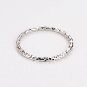 Macro view of minimalist silver textured band ring with sparkling hammered surface