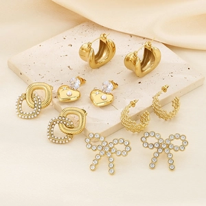 Detail view of 18K gold plated heart and bow earrings with pearls on stone and silk