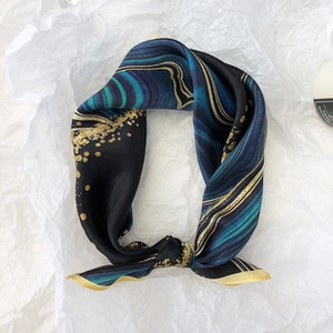 Detailed view of luxury mulberry silk scarf with blue and gold marble texture pattern