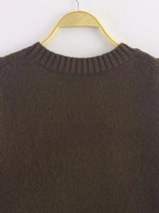 Close-up of dark brown knit sweater neckline with rib-knit texture and soft mohair feel