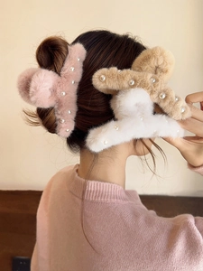 Detail of plush faux fur hair claws in pink, khaki, and white with pearl accents