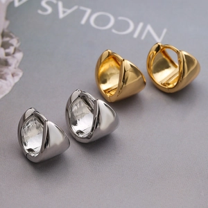 Minimalist geometric triangle hoop earrings in gold and silver finish on soft fabric