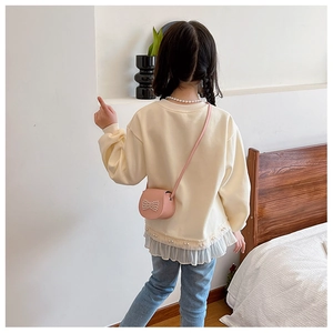 Detail of cream girls sweatshirt with faux pearl necklace and pleated ruffle hem
