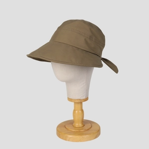 Detail of khaki sun hat with wide brim and elegant bow decoration on wooden stand