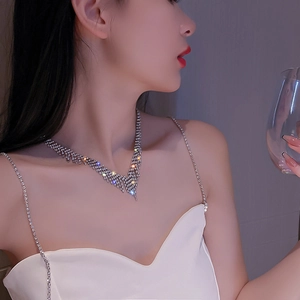 Gros plan d'un collier choker argenté en forme de V avec des strass étincelants