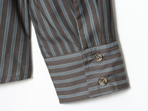 Détail du poignet à double boutonnage sur une chemise en popeline de coton rayée bleu