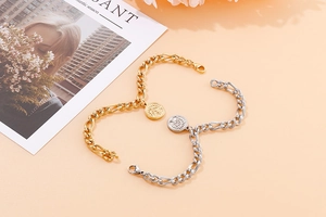 Detail of gold and silver Tree of Life coin pendants on thick Figaro chain bracelets