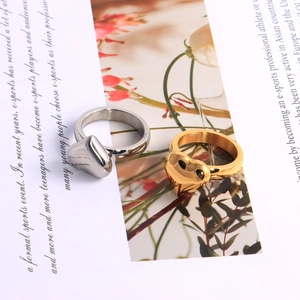 Flat lay of heart-shaped gold and silver titanium steel rings on a magazine page