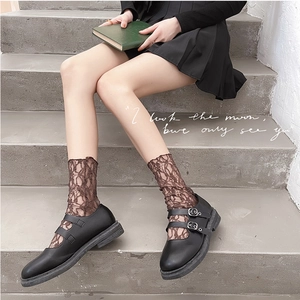 Calze di pizzo marroni con motivi floreali e scarpe Mary Jane nere con suola a zeppa