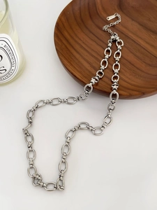 Detail of silver chain necklace with lobster clasp and extender on a wooden tray
