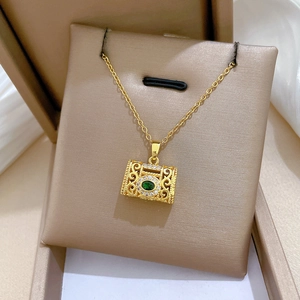 Close-up of vintage gold titanium necklace with emerald stone and sparkling zircon detail