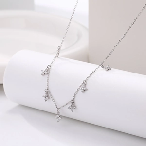 Macro shot of silver necklace featuring five delicate flower pendants set with cubic zirconia