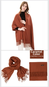 Detail view of caramel cashmere scarf texture with soft fringes and quality material tag
