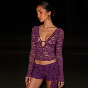 Détail du haut en dentelle violette à manches longues avec décolleté en V profond