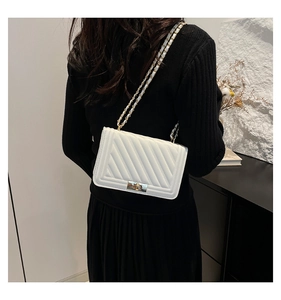 Close-up of white quilted PU leather crossbody bag with golden chain and metal lock detail