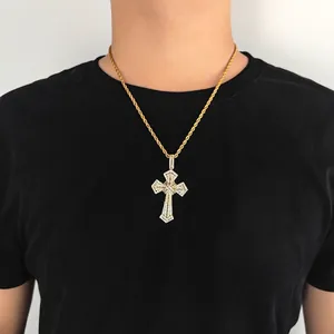 Hip hop style gold cross pendant with cubic zirconia and rope chain on a male model