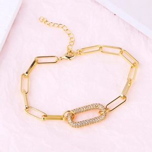 Detail of gold-plated paperclip chain bracelet with a clear zircon oval centerpiece