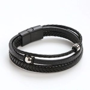 Detail of multi-layer black braided leather bracelet with magnetic buckle and silver beads