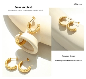 Detailed views of gold C-shape hoop earrings with vintage twisted texture on display