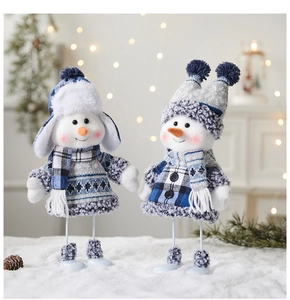 Close-up of blue knitted Christmas snowman figurines with scarves and hats in a cozy scene