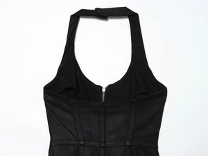 Detail view of the back zipper and halter neckline on a black denim dress garment