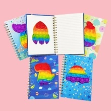 Macro detail of rainbow silicone pop-it spiral notebooks with internal lined paper