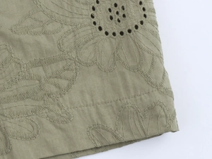 Close-up of khaki floral embroidery and perforated eyelet fabric detailing