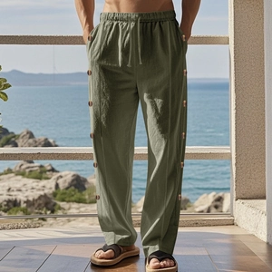 Close-up of olive green linen trousers featuring drawstring waist and side button details