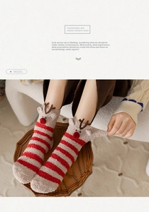 Detail of red and cream striped thermal Christmas socks with 3D reindeer decor