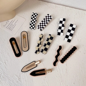 Flat lay of multiple checkered and patterned hair claws in various elegant styles