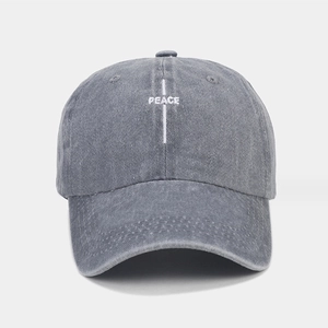 Gros plan détaillé de la broderie PEACE blanche sur une casquette en coton gris lavé