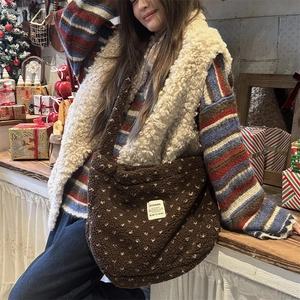 Detail of coffee brown plush crossbody bag with white heart pattern and soft texture
