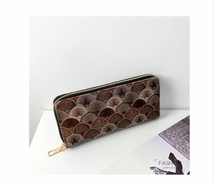 Detail of embroidered long wallet with fan-shaped patterns and gold zipper closure