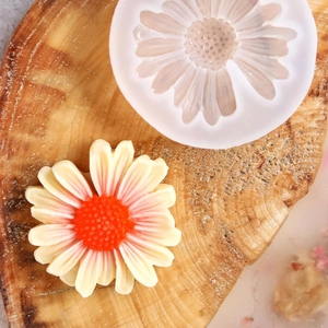 Daisy flower silicone mold for handmade candles and soaps on a rustic wood background