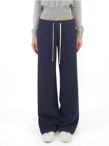 Detail of navy blue wide-leg sweatpants with contrast cream-colored drawstring waist