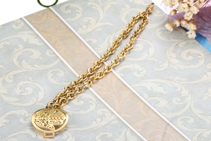 Detail of a golden double-layered titanium steel bracelet with Hamsa Hand pendant