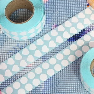 Macro detail of light blue diamond painting heart and round stickers for DIY sorting