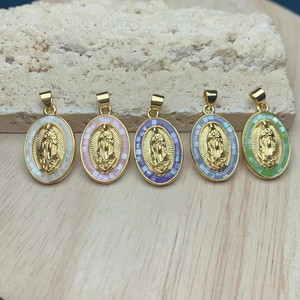 Detailed view of colorful oval religious pendants with gold finish on a stone surface