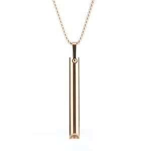 Macro shot of minimalist gold mindfulness breathing pendant with smooth cylindrical tube detail