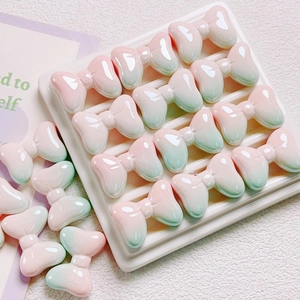 Macro detail of pink and green gradient resin bow beads with high gloss finish