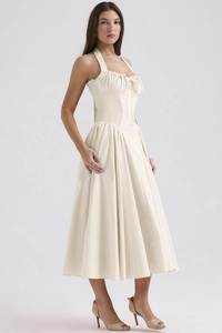 Side view of cream-white halter midi dress with slim fit waist and flared skirt hem