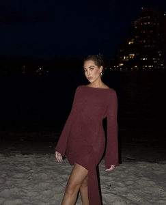 Détail de la robe en tricot bordeaux avec manches évasées et nœud élégant à l'ourlet