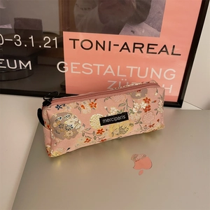 Detail of floral embroidery on a pink pencil case with a metal ring zipper pull