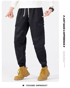 Detail of men's camouflage cargo pants showing drawstring waist and large side pockets
