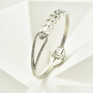 Silver wheat leaf hinged bangle with sparkling round center stone on white pedestal