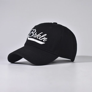 Detailed close-up of white Brkln script embroidery on a black cotton baseball cap