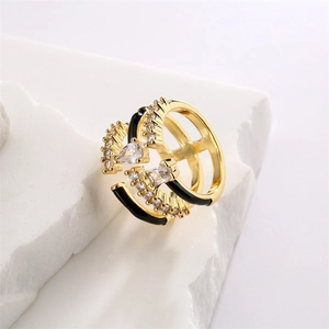Close-up of golden multi-layer ring with black enamel lines and sparkling zircon stones