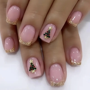 Pink press-on nails with gold glitter French tips and 3D Christmas tree charms.